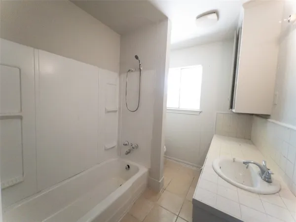 a bathroom with a tub a sink a vanity and a shower