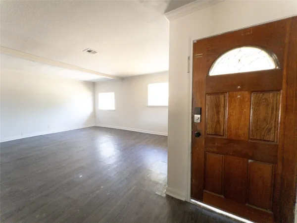an empty room with wooden floor and a window