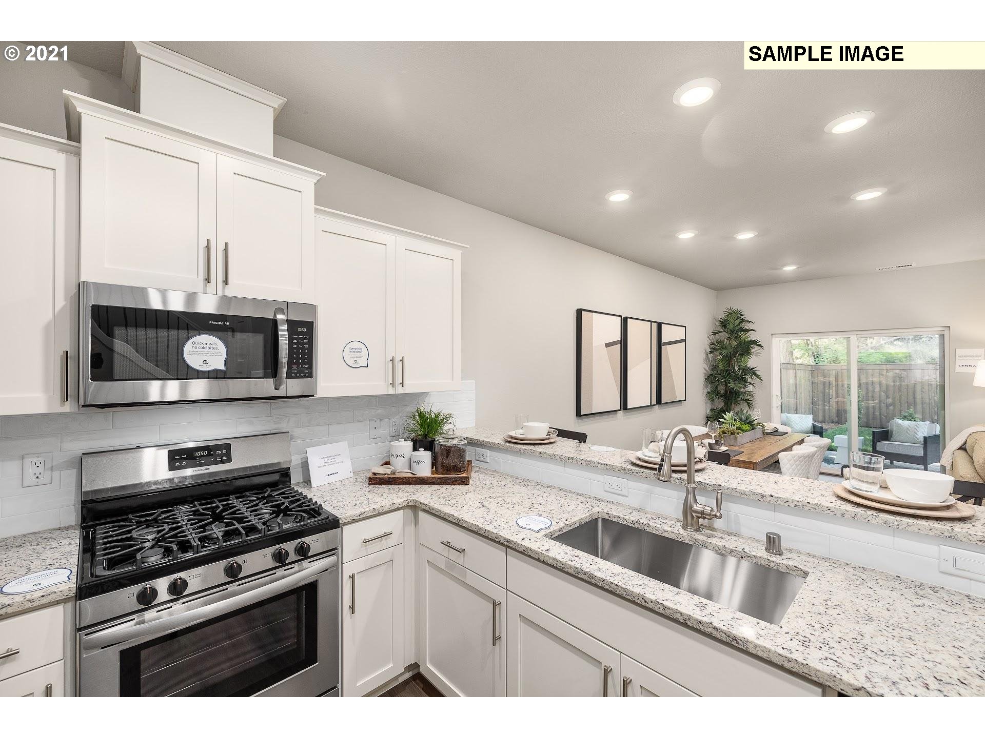 4230 South Waters Edge Way Ridgefield, WA 98642 - Photo 3 of 24 a kitchen with stainless steel appliances a sink a stove and microwave