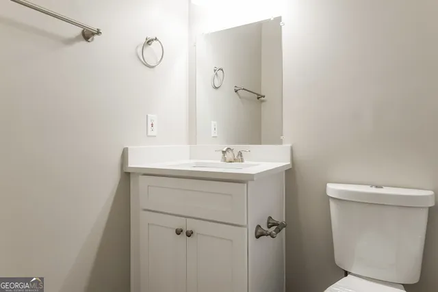 a bathroom with a sink a toilet and a mirror