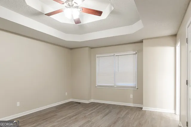 an empty room with windows and fan