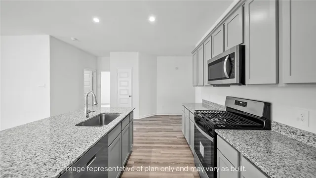 a kitchen with stainless steel appliances granite countertop a sink stove and cabinets