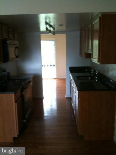 7922 Spring Forest Court, Unit 4A Springfield, VA 22152 - Photo 12 of 12 a kitchen with granite countertop a stove and a refrigerator