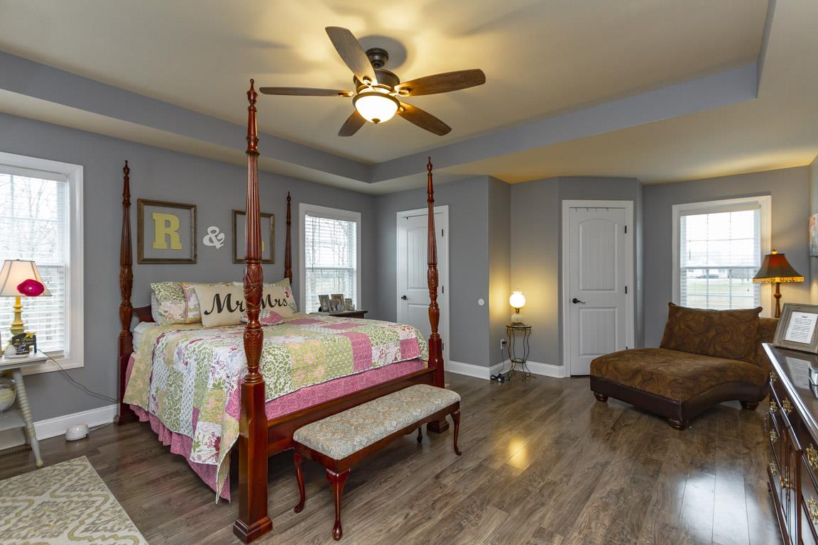 231 Calvert Ridge Road Westmoreland, TN 37186 - Photo 17 of 27 a spacious bedroom with a bed a chandelier and a dresser