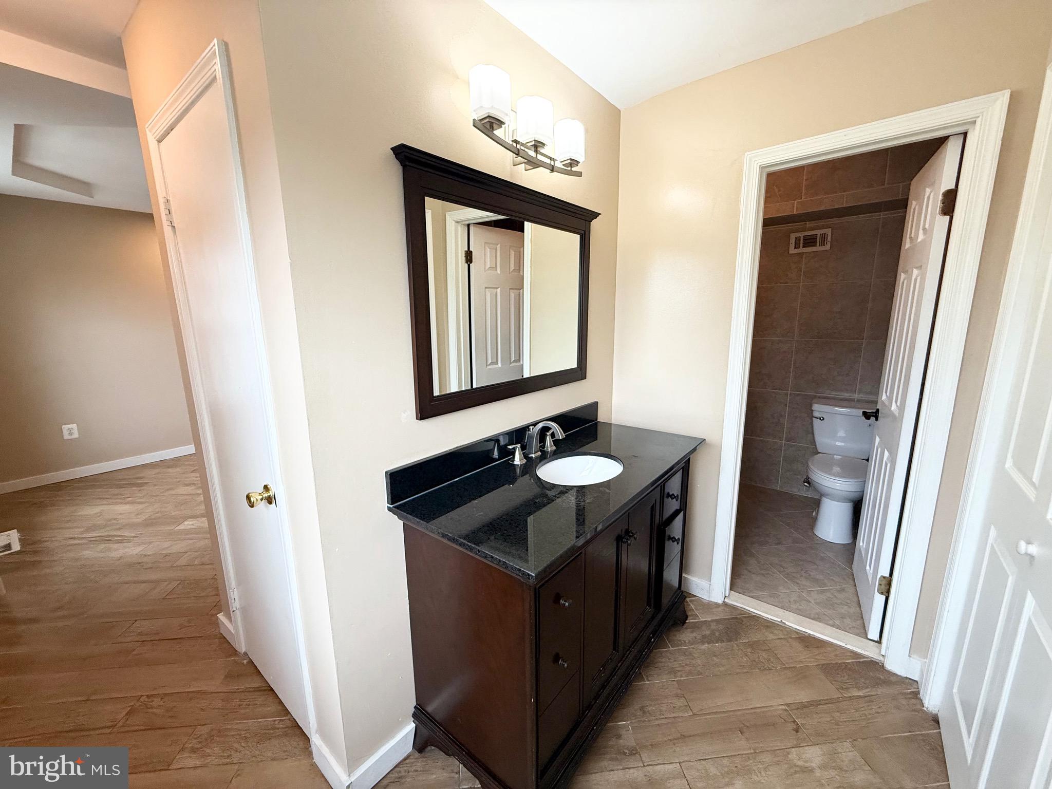5439 Richenbacher Avenue Alexandria, VA 22304 - Photo 13 of 23 a bathroom with a granite countertop sink and a mirror
