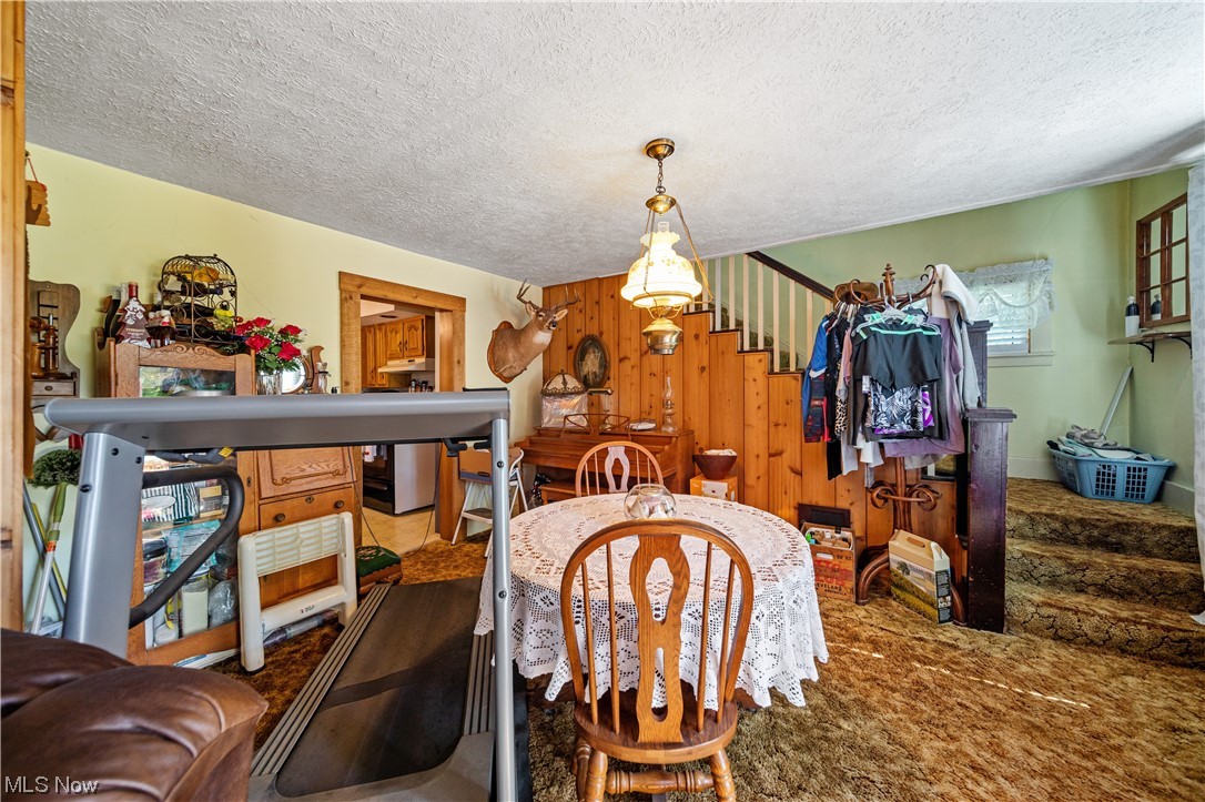 6863 Barrett Road Geneva, OH 44041 - Photo 8 of 35 Carpeted dining room with a textured ceiling and a chandelier