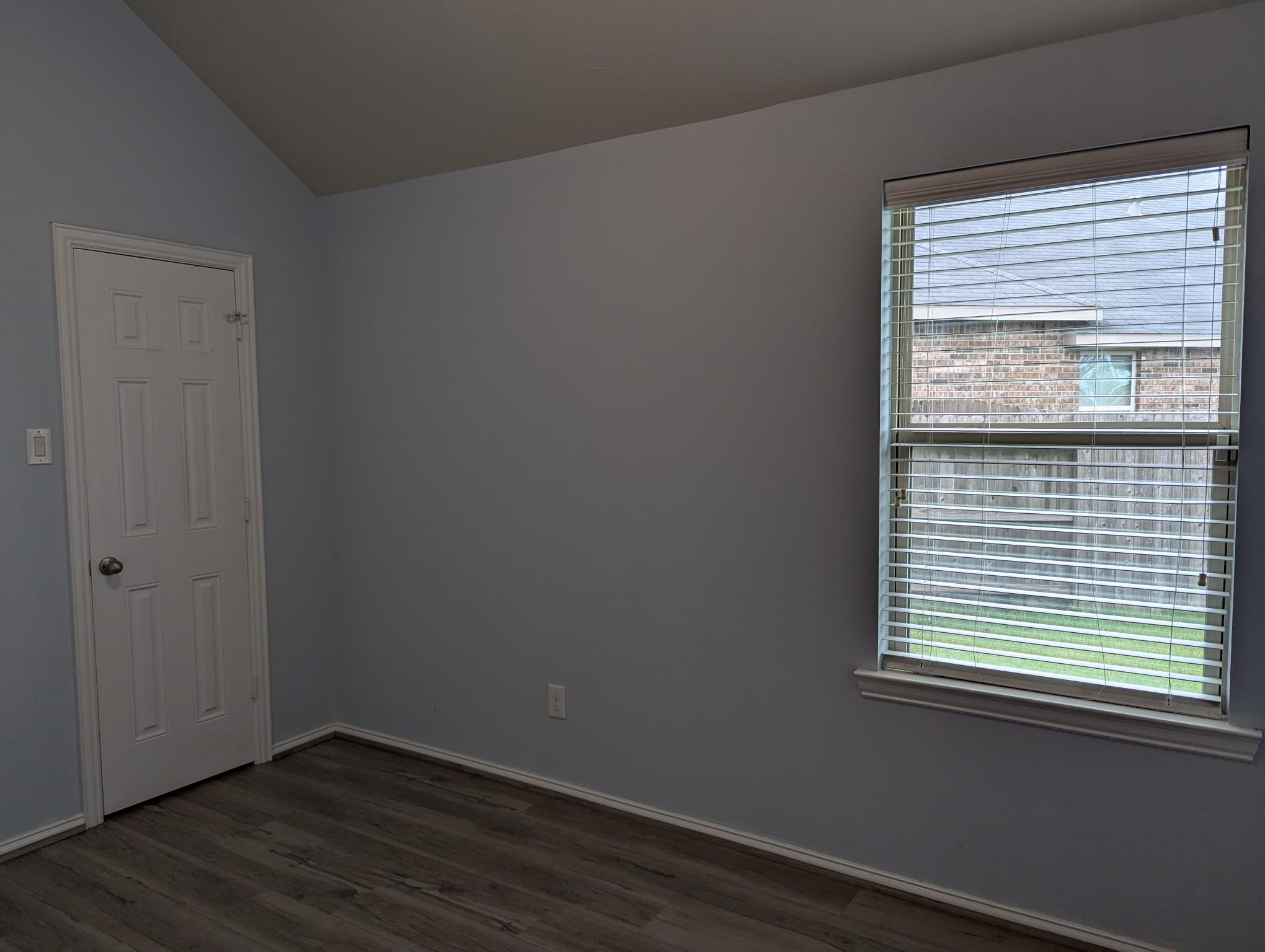 8041 Silent Deep Drive Rosenberg, TX 77469 - Photo 22 of 24 Another view of the bedroom two with laminate flooring, a window with blinds that provide natural light, and a white door.