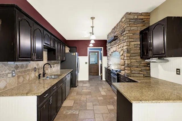 a kitchen with granite countertop stainless steel appliances and a sink