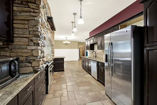 a kitchen with stainless steel appliances granite countertop a refrigerator and a stove