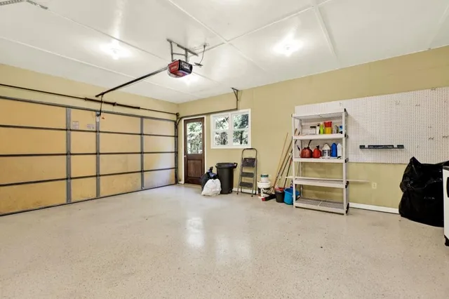 a view of a kitchen with a fridge a ceiling fan and wooden floor