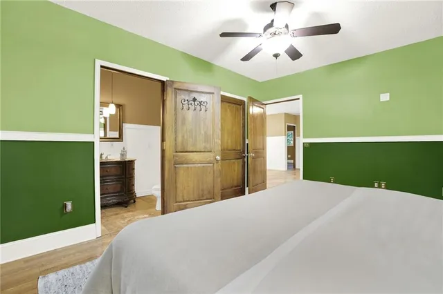 a view of an empty room with window wooden floor and a ceiling fan