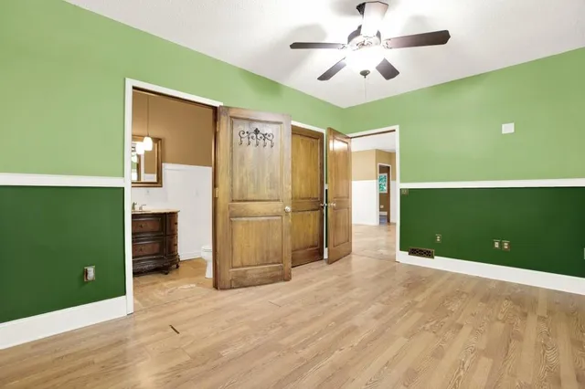 a view of a livingroom with wooden floor and a ceiling fan
