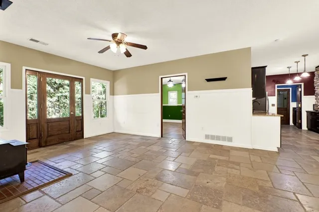 a view of a livingroom with a ceiling fan and window