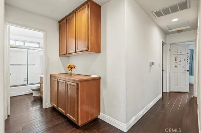 a utility room with wooden floor washer and dryer
