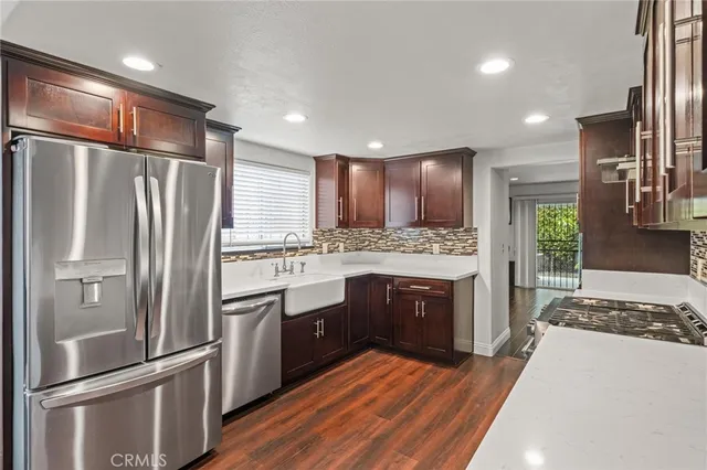 a kitchen with stainless steel appliances granite countertop a refrigerator a stove and a sink