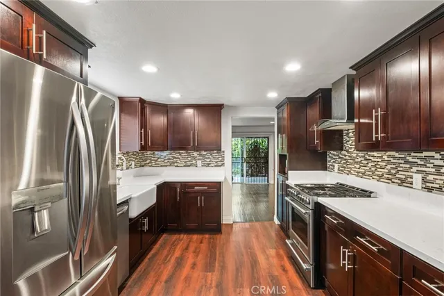 a kitchen with kitchen island granite countertop a stove refrigerator and cabinets