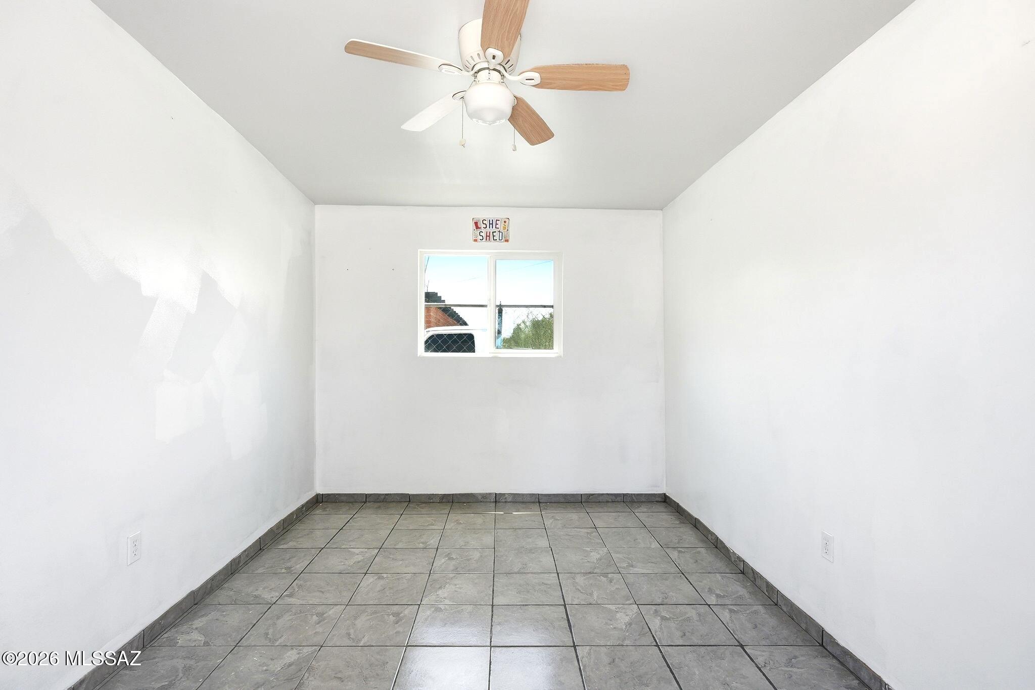 5125 South Missiondale Road Tucson, AZ 85706 - Photo 23 of 32 an empty room with a ceiling fan and a window