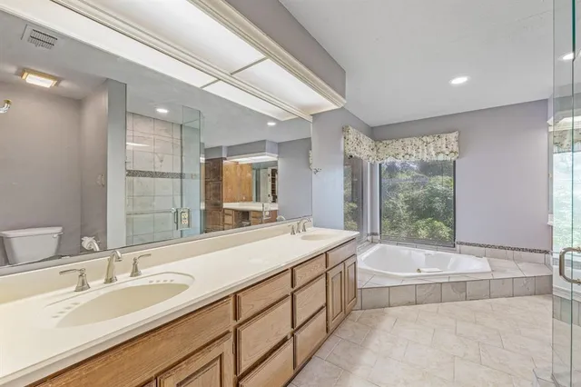 a spacious bathroom with a tub sink and mirror