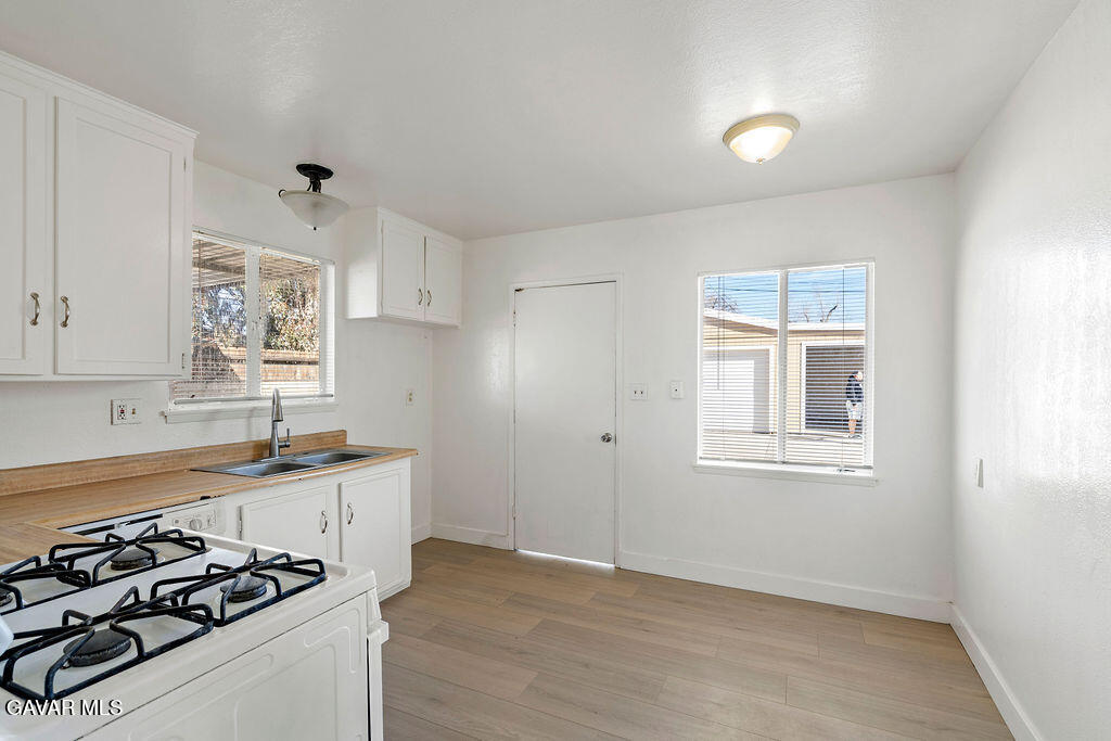 44152 Elm Avenue Lancaster, CA 93534 - Photo 3 of 17 a kitchen with a stove a sink and a window