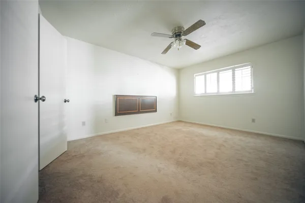 a view of a livingroom with a ceiling fan and window