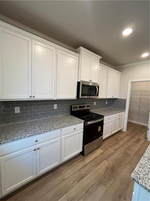 4501 Ajo Walk Atlanta, GA 30331 - Photo 5 of 16 a kitchen with granite countertop white cabinets and wooden floor