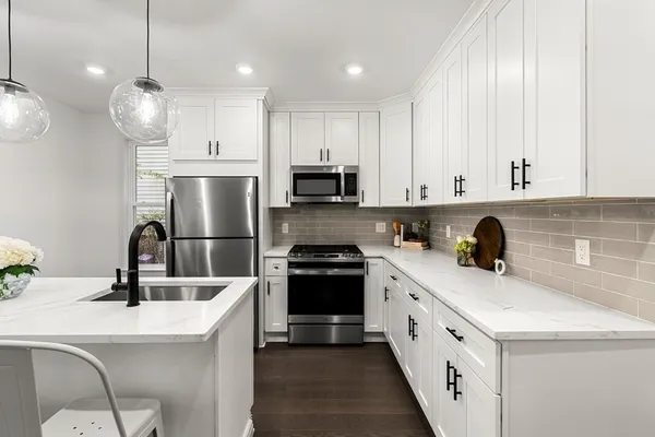 a kitchen with white cabinets and stainless steel appliances