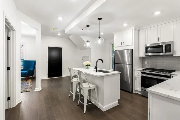 a kitchen with stainless steel appliances kitchen island a refrigerator and a stove top oven