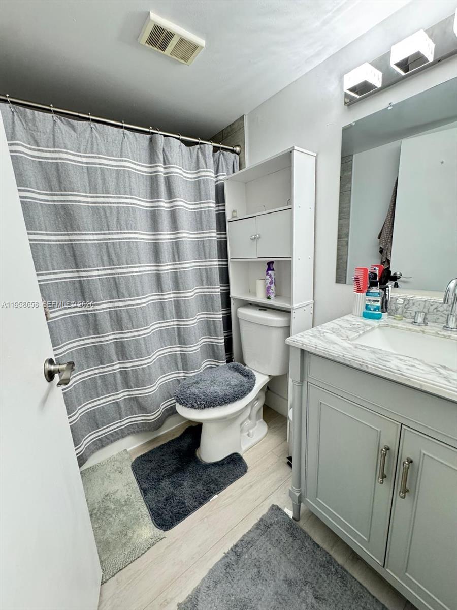 8801 Wiles Road, Unit 308 Coral Springs, FL 33067 - Photo 11 of 16 a bathroom with a sink toilet and shower