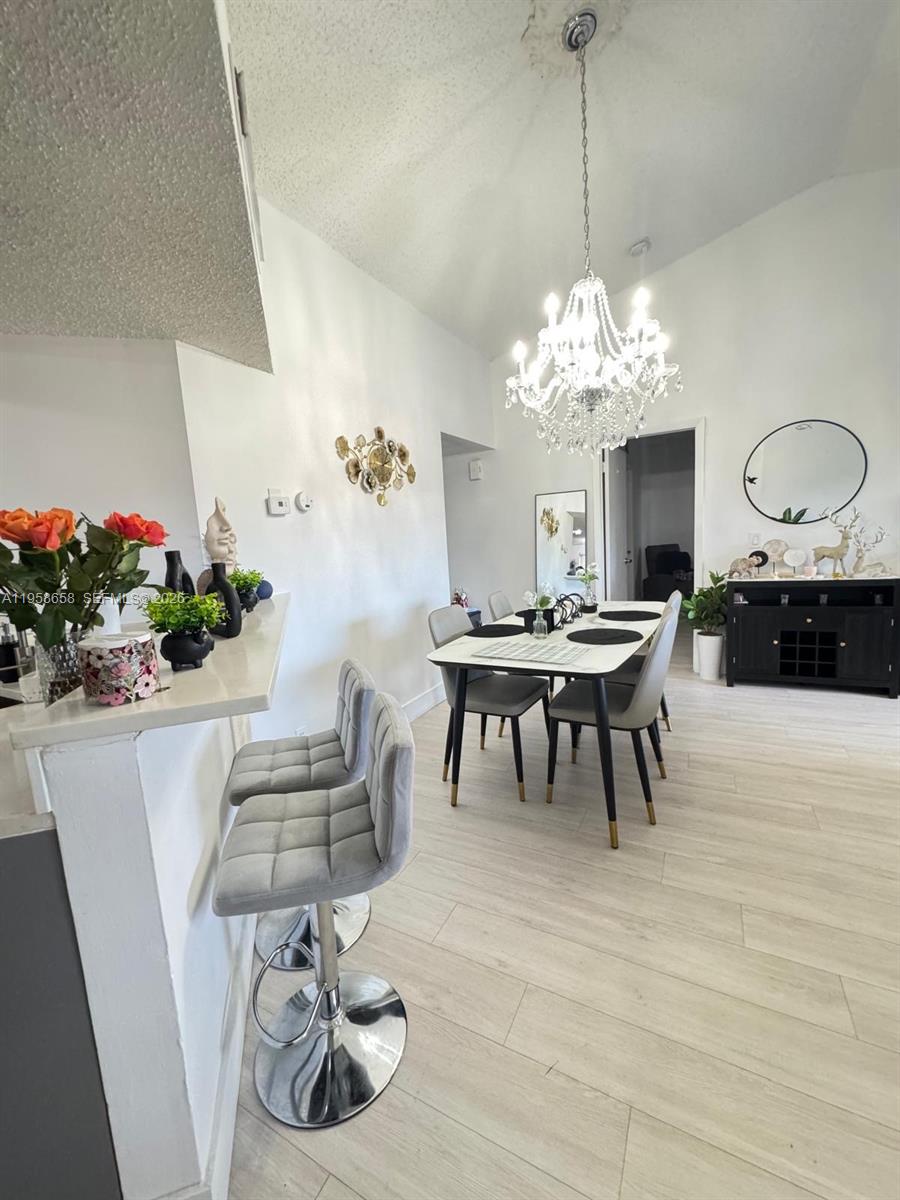 8801 Wiles Road, Unit 308 Coral Springs, FL 33067 - Photo 14 of 16 a view of a dining room with furniture and chandelier