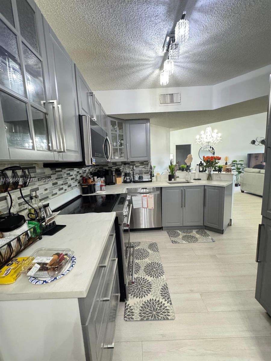 8801 Wiles Road, Unit 308 Coral Springs, FL 33067 - Photo 2 of 16 a kitchen with a stove a refrigerator and a sink