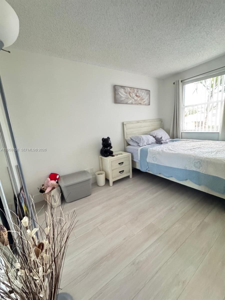 8801 Wiles Road, Unit 308 Coral Springs, FL 33067 - Photo 9 of 16 a bedroom with a bed and window