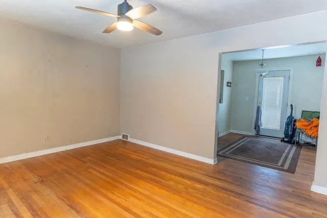 a view of empty room with wooden floor