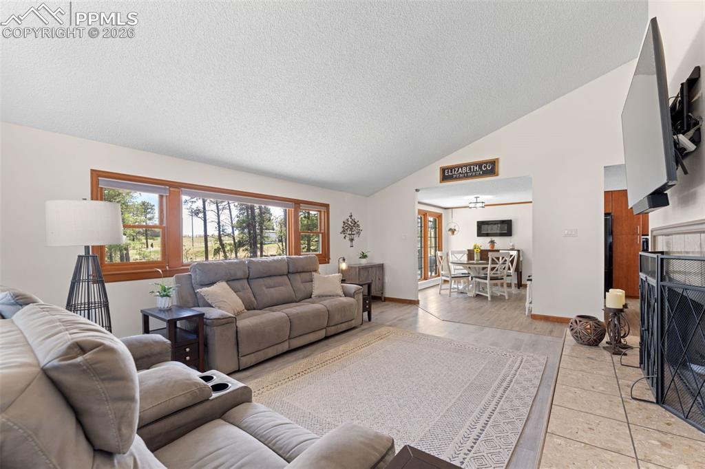 1851 Buttercup Road Elizabeth, CO 80107 - Photo 9 of 47 a living room with furniture a large window and a flat screen tv