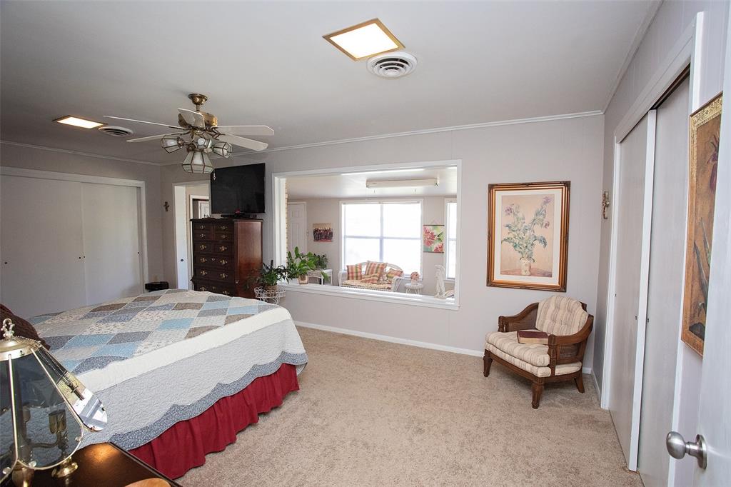 914 Fairview Street Graham, TX 76450 - Photo 8 of 17 a spacious bedroom with a bed and a chandelier