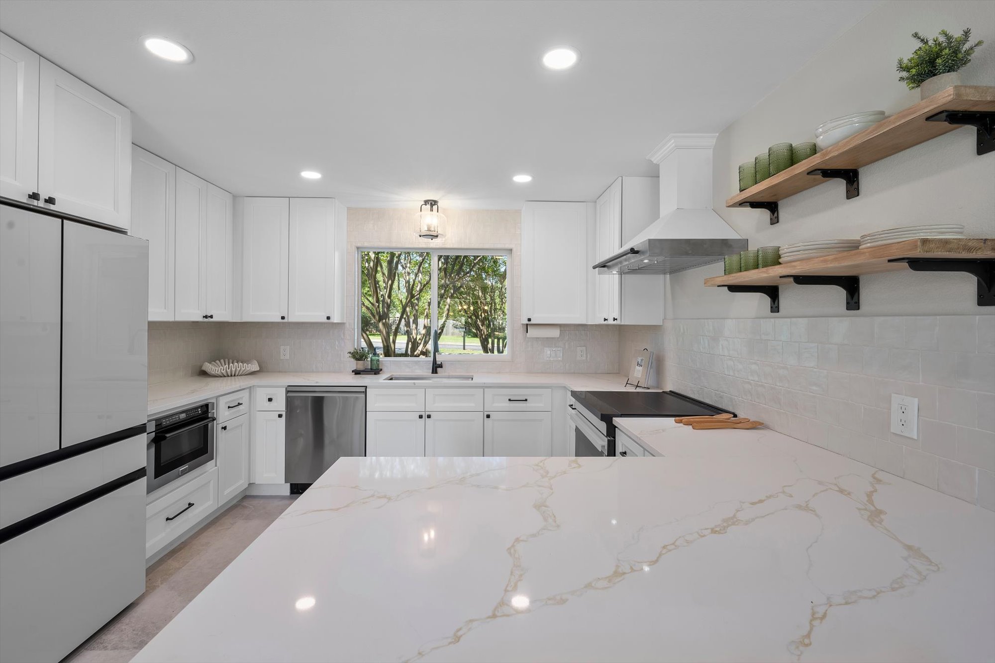 109 Woodland Road Georgetown, TX 78628 - Photo 15 of 40 Modern kitchen with sleek white cabinetry, gleaming countertops, and an abundance of natural light.