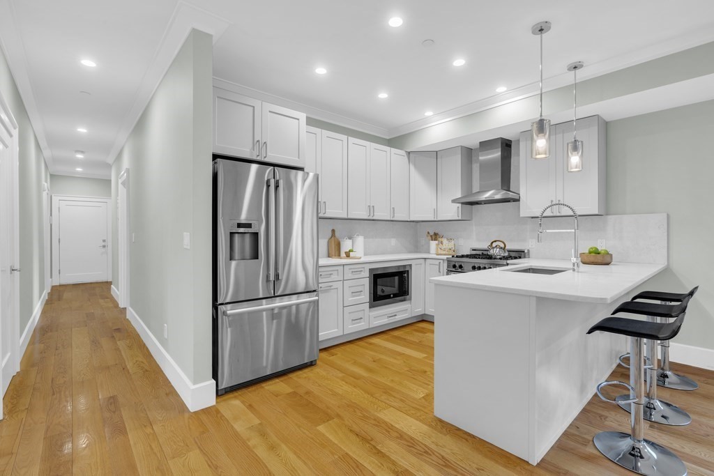 17 Vinton Street, Unit PH Boston, MA 02127 - Photo 12 of 36 a kitchen with kitchen island white cabinets and stainless steel appliances