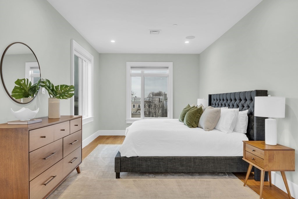 17 Vinton Street, Unit PH Boston, MA 02127 - Photo 18 of 36 a bedroom with a large bed and a chandelier