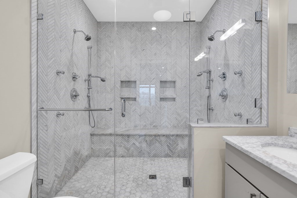 17 Vinton Street, Unit PH Boston, MA 02127 - Photo 27 of 36 a bathroom with a granite countertop shower a mirror and vanity