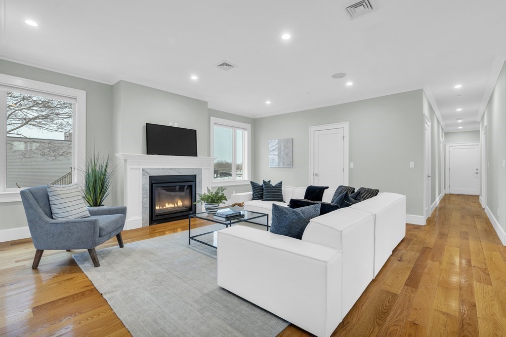 17 Vinton Street, Unit PH Boston, MA 02127 - Photo 3 of 36 a living room with furniture a fireplace and a flat screen tv