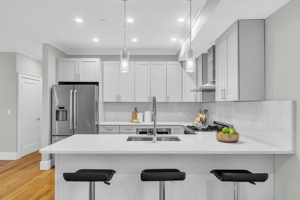 17 Vinton Street, Unit PH Boston, MA 02127 - Photo 9 of 36 a kitchen with stainless steel appliances granite countertop a sink a stove and a refrigerator