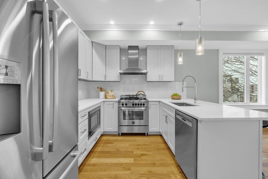 17 Vinton Street, Unit PH Boston, MA 02127 - Photo 10 of 36 a kitchen with stainless steel appliances granite countertop a stove a sink and a refrigerator