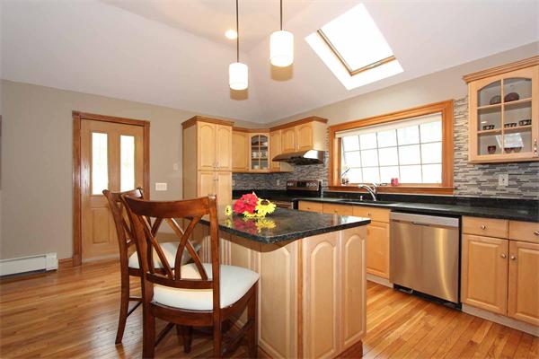 23 Wallace Road Wayland, MA 01778 - Photo 8 of 25 a kitchen with stainless steel appliances granite countertop a stove a sink dishwasher a dining table and chairs with wooden floor