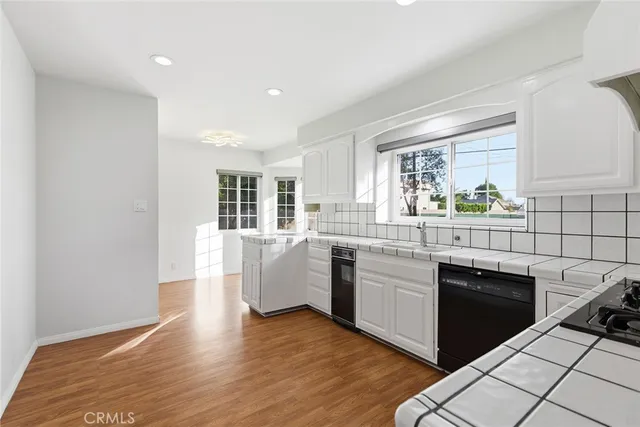 a kitchen with a sink cabinets and wooden floor