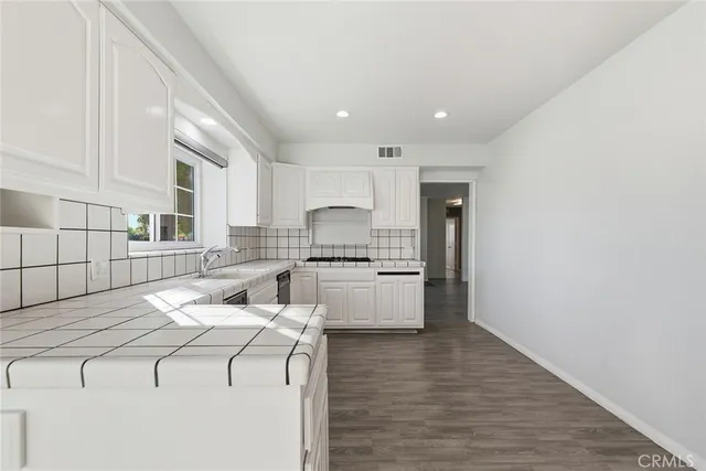 a kitchen with granite countertop white cabinets and white appliances