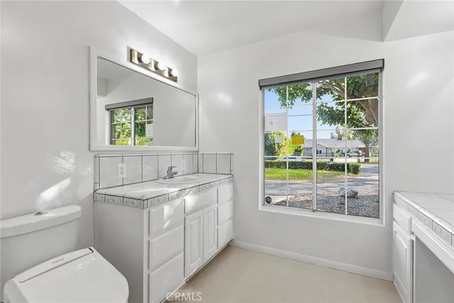 a bathroom with a sink a toilet and a window