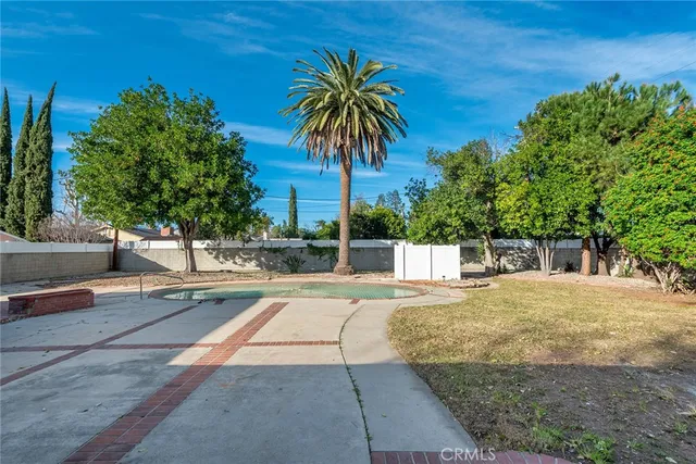 a view of a backyard with couches under an umbrella
