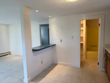 wooden floor in a hall with an entryway and a room