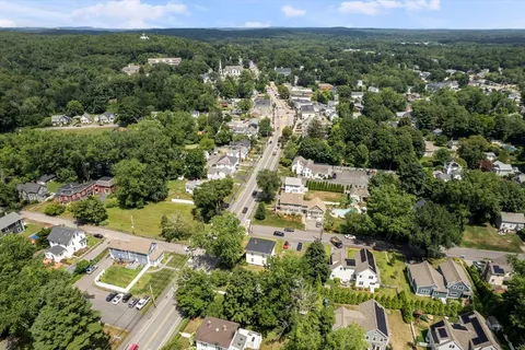 an aerial view of residential houses with outdoor space and trees