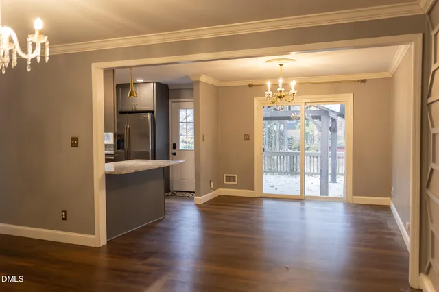 a view of a big room with wooden floor and windows