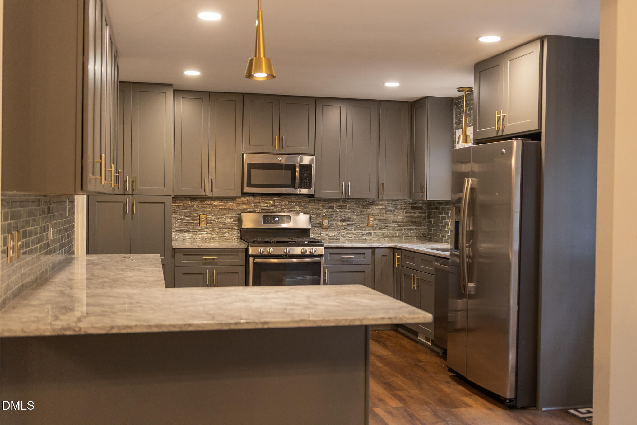 6708 Spencer Court Raleigh, NC 27615 - Photo 14 of 35 a kitchen with kitchen island granite countertop stainless steel appliances and refrigerator